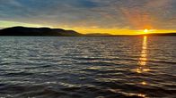 Kuvassa näkyy pallastunturit ja yöttömän yön aurinko.