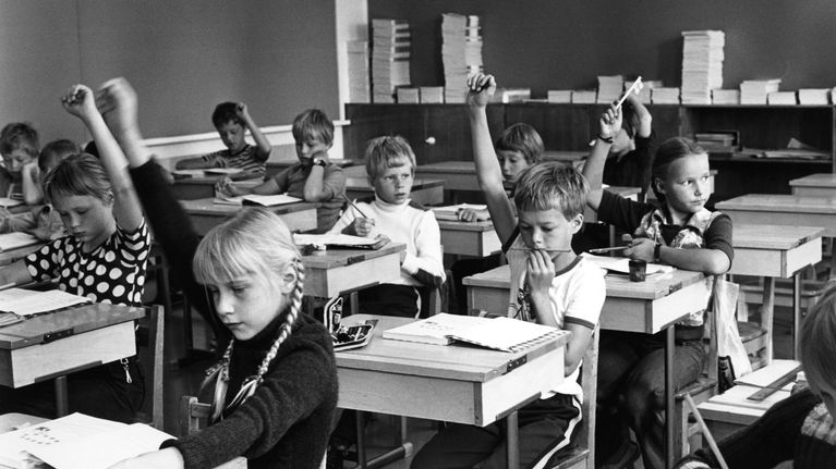 Peruskoulun luokka, jossa lapset viittaavat.