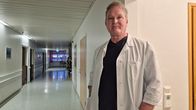 Ortopedi Juhani Juntunen seisoo sairaalan käytävällä. Vasemmalla tyhjä hämyinen käytävä.