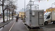 Mätningsstation för luftpartiklar vid ett torg med gång- och cykelväg i regnigt vinterväder.