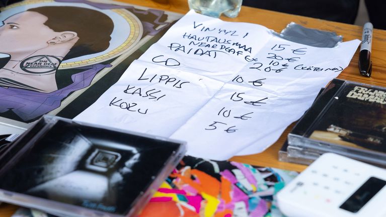 Pöydälle on aseteltu levyjä ja käsin kirjoitettu hinnasto.