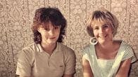 Valokuvassa Leena Harmas ja Susanna Sirén-Valanta istuvat vierekkäin ja katsovat kameraan. Muodista ja meikistä näkee, että kuva on 1980-luvulta.