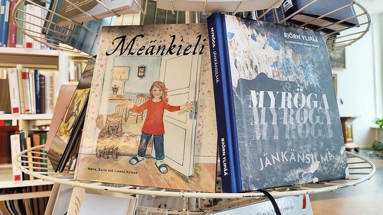 Meänkielisiä kirjoja hyllyssä.