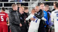 Suomen miesten jalkapallomaajoukkueen päävalmentaja Jacob Friis halaa puolustaja Nikolai Alhoa Puola-ottelun jälkeen.