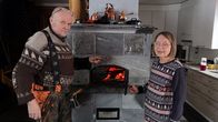 Tapani ja Ulla Rantajääskö seisovat leivinuunin ääressä, uunin luukku on auki.
