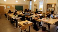 Ett klassrum med elever sittande vid sina pulpeter.
