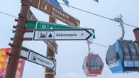 Hiihtokeskuksen suuntaviittoja ja gondolihissejä.