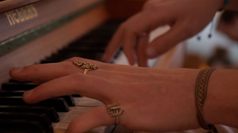 Händerna på man som spelar piano.