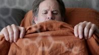 Patrik (Robin Svartström) makaa sängyssä raottaen peittoa ja katsoen alavartaloaan. 