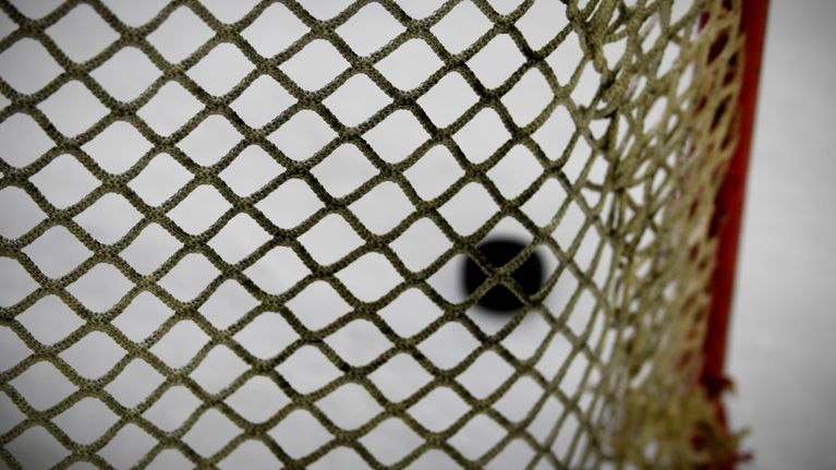 Puck i ishockeymål.