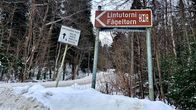 Skylt på en snöig väg med pil mot fågeltornet på Svinö.