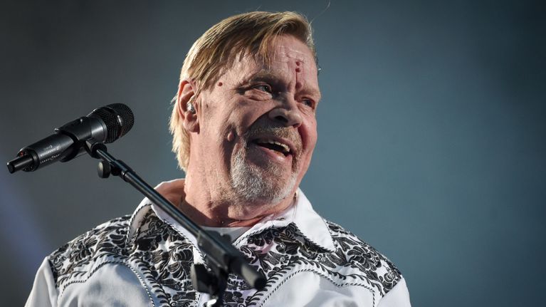 Vesa-Matti Loiri istuu juhlakonsertissaan lavalla ja nauraa katsoen yleisön suuntaan.