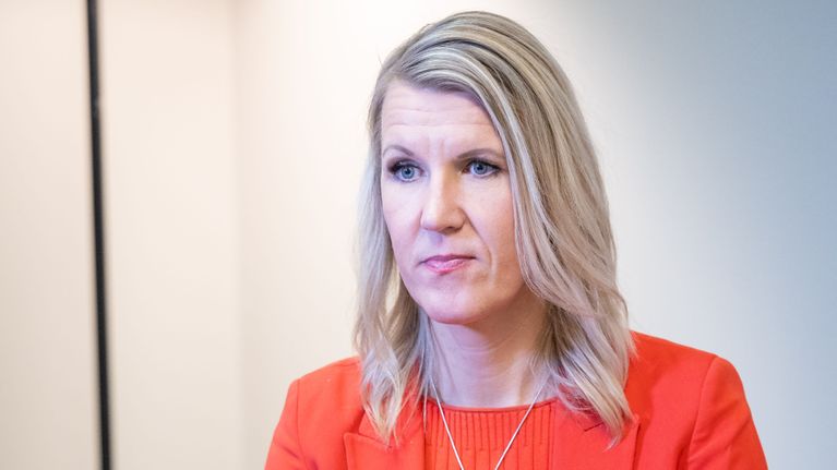 Sari Multala istuu oranssissa jakussaan.