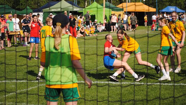 En handbollsmatch spelas på gräsplan.