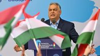 Viktor Orban pitää puhetta unkarinlippujen liehuessa edustalla. 