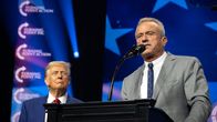 Robert F. Kennedy Junior puhuu puhujanpöntössä ja taustalla Donald Trump katselee Kennedyä.