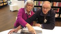 Enter-järjestön vertaisopastaja Raimo Anttila kirjastossa tietokoneen takana, opastettavana Irma Pantzar.