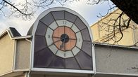 Karkkilan Yhteiskoulu ja liikuntahalli, iso, värikäs kello ulkoseinällä.