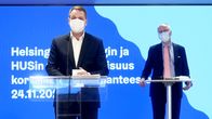 Två män står vid sina podium och håller presskonferens. 