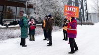 Lakkovahteja kylttien kanssa talvisella pihamaalla.