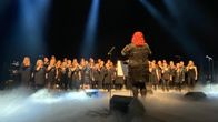 Varkauden laulun kuoro ja kuoronjohtaja lavalla. 