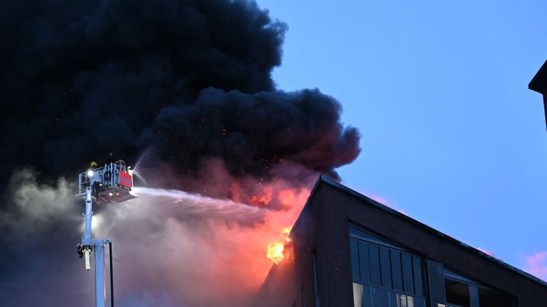 Pelastuslaitos sammuttaa tulipaloa Kalasataman kerrostalossa, pelastushenkilöstöä on korkealla nostokorissa ja he suihkuttavat vettä suoraan tuleen.