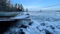 Talvinen järvenranta. Kuvan etualalla soutuvene, jonka airo on jäätynyt pitkille puikoille.