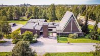 Lähemäen seurakuntatalo lintuperspektiivistä kuvattuna. Seurakuntatalo on tiilinen ja harjakattoinen.