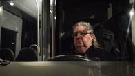 Kuvassa on Lahden seudun liikenteen bussinkuljettaja Tuija Tahvanainen kuvattuna bussin ikkunan takaa.