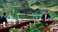 Antony Blinken ja Xi Jinping istuvat suuren pöydän ääressä suhteellisen kaukana toisistaan.