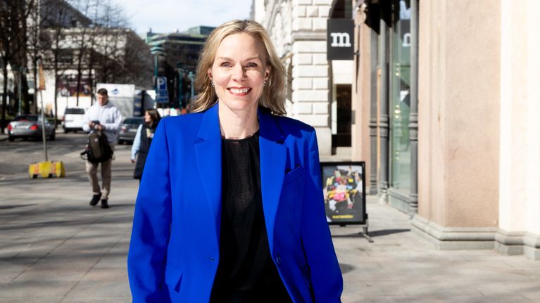 Anu Bardford kävelee kadulla sinisessä bleiserissä.