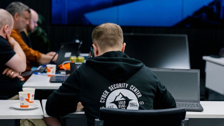 Ihmisiä istumassa tietokoneilla kyberharjoituksessa.