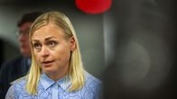 Elina Valtonen puhumassa medialle vaaleansinisessä, kirjaillussa kauluspaidassa.