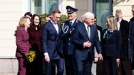 Ryhmä henkilöitä seisoo presidentinlinnan edustalla.