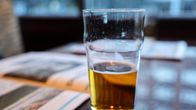 Photo shows a pint of lager on a table.
