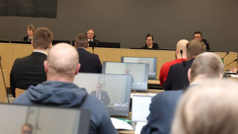 Ihmisiä oikeussalissa.