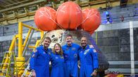 Neljä astronauttia poseeraa kameralle sinisissä haalareissa.