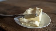 Pienellä valkoisella lautasella palavoita ja siihen nojaava voiveitsi.