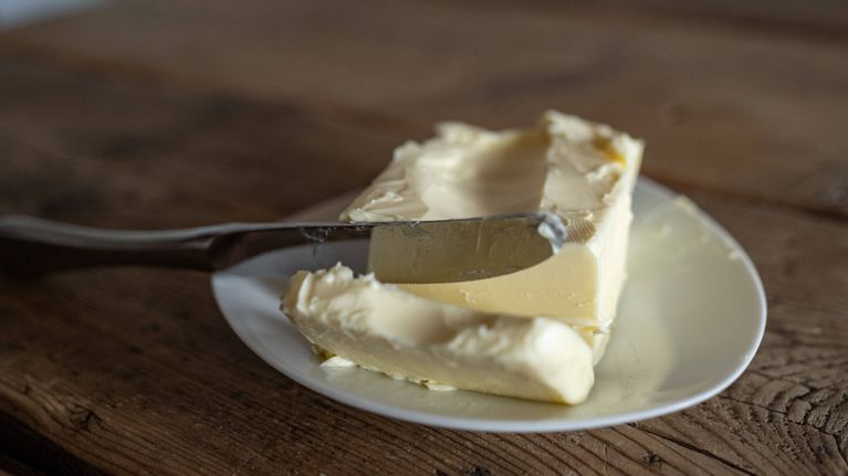 Pienellä valkoisella lautasella palavoita ja siihen nojaava voiveitsi.