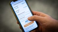 Mies selaa puhelimella rahoitusyhtiöiden lainatarjouksia.