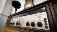 Sata vuotta vanha suomalainen radio sekä siihen aikaan radion kaiuttimena toiminut saman ikäinen gramofonin torvi.