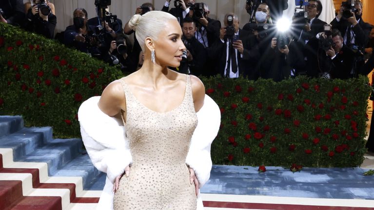 Kim Kardashian  Marilynin tiukassa vaaleassa mekossa salamavalojen välkkeessä.
