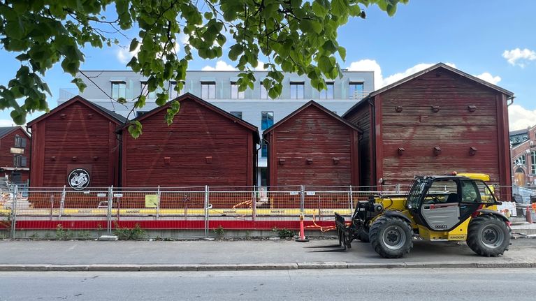 Punaisia aittarakennuksia rakennustyömaan laidalla. 