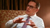 Alexander Stubb istuu nojatuolissa ilman pikkutakkia, puhuu vilkkaasti käyttäen käsiään.