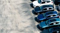 Uusia autoja rivissä parkkipaikalla.