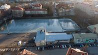 Flygbild över Barkplan i Åbo, man ser en stor plan med glänsande is och bland annat höghus runt. 