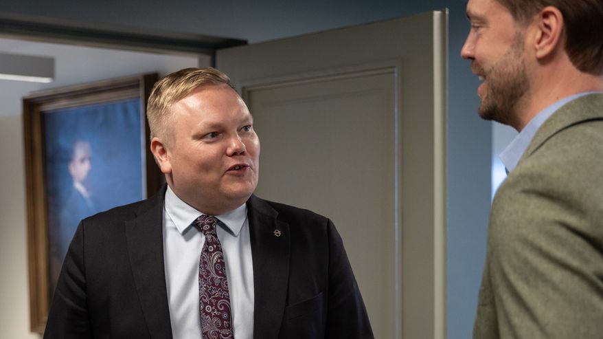 Kaksi miestä juttelee käytävällä.