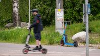 Mies ajamassa sähköpotkulaudalla.