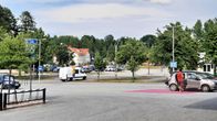 Autoja parikkipaikalla. Taustalla vaalei puurakennus, joka on Parikkalan rautatieasema. 