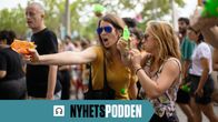 Två kvinnor står med varsin vattenpistol och riktar dem mot turister under en demonstration i Barcelona under sommaren 2024. 